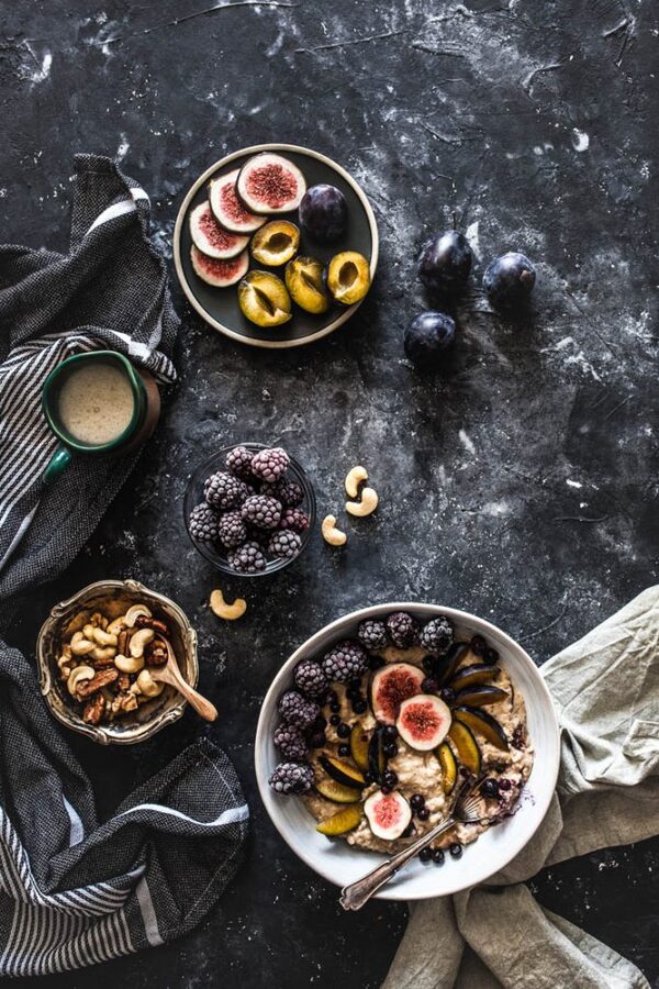 Bol con avena, fruta y semillas en una mesa de madera