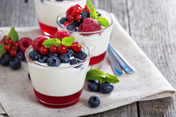 Mesa ordenada con cuenco de yogur y frutos rojos